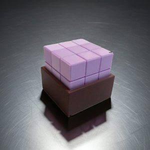 Puzzle 3D impreso en 3D con cubo geométrico morado encajado en base negra